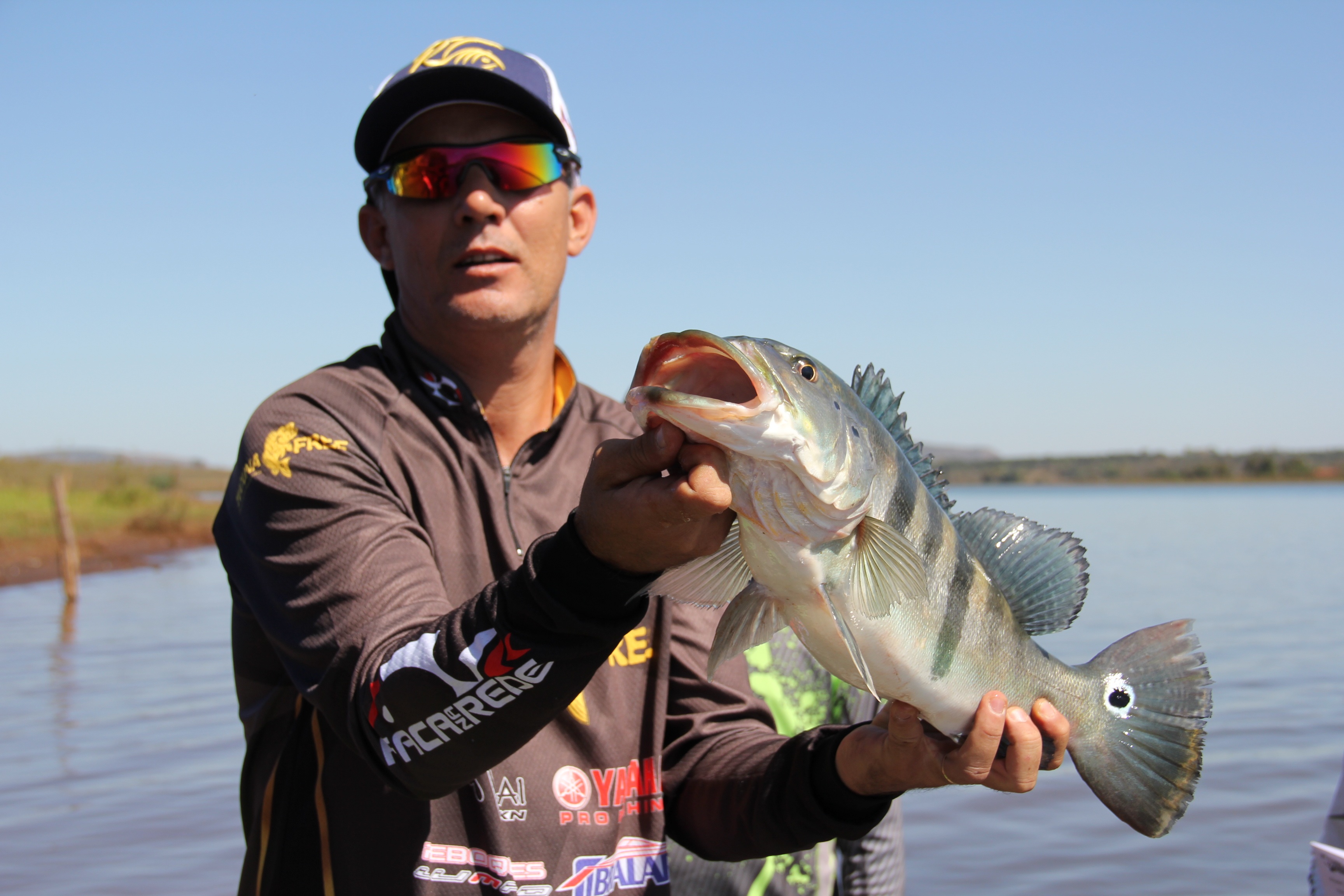 An angler holding a large bass at a Discovery Bay fishing event